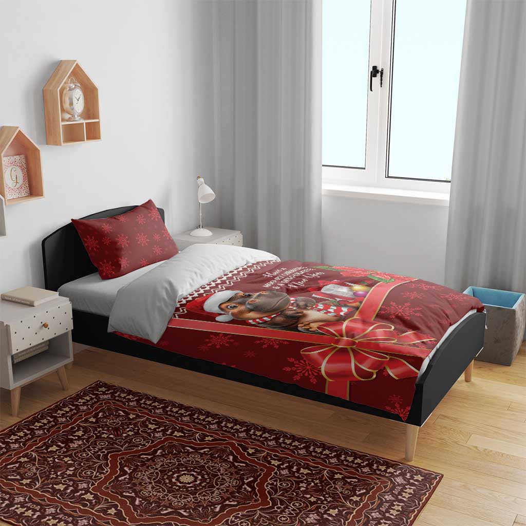 Red cow Christmas duvet and pillow set with holiday border and gift bow, on bed