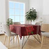 Red Christmas tablecloth with poinsettia, snowflake, and ribbon pattern.