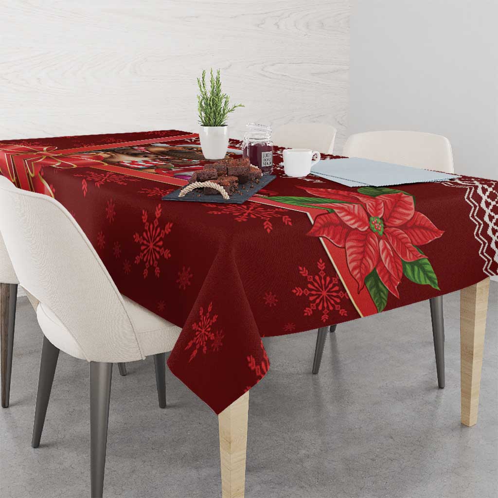 Red Christmas tablecloth on dining table with poinsettia and snowflake pattern.