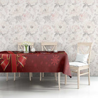 Red Christmas tablecloth across dining table with snowflake and floral border print.