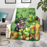Green St. Patrick's Day blanket with cartoon hippo, clovers and gold coins, on gray rug