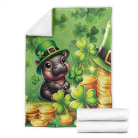 Green St. Patrick's Day blanket with cartoon hippo, clovers and gold coins, folded with two towels