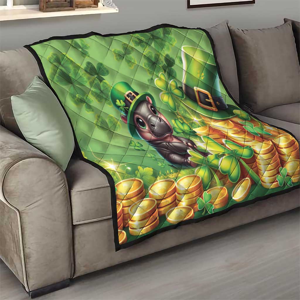 Green quilt draped on sofa with cartoon moose, shamrocks, and gold coins, quilted panels