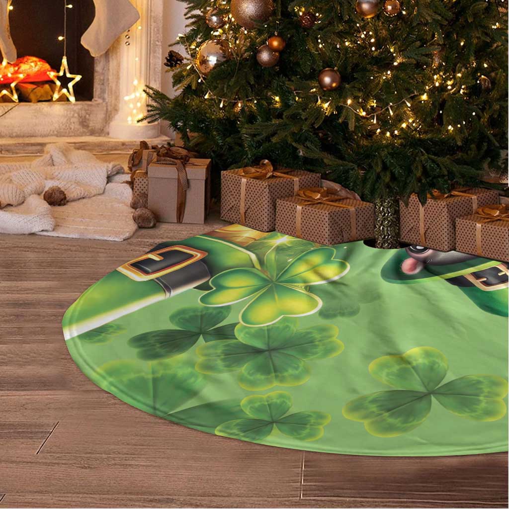 Green round tree skirt laid on floor, fringed edge with shamrock and coin graphic