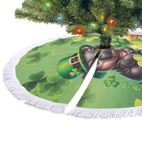 Green round tree skirt with white fringes and mouse clover graphic under tree