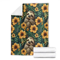 Green sloth and flower blanket with yellow blooms and sloth portraits, plus folded white fabric