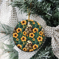 Round ceramic ornament with sloth face and orange flowers on dark green tropical leaf design