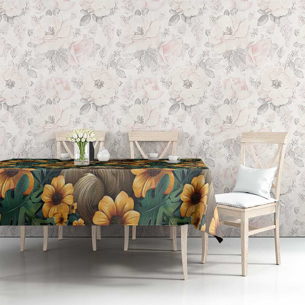 Green tablecloth with sloths and yellow flowers, dining table styling with chairs.