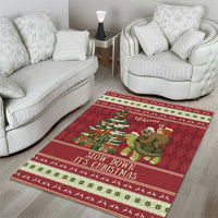 Red holiday area rug on wood floor with turtle-riding sloth and snail, Christmas message border