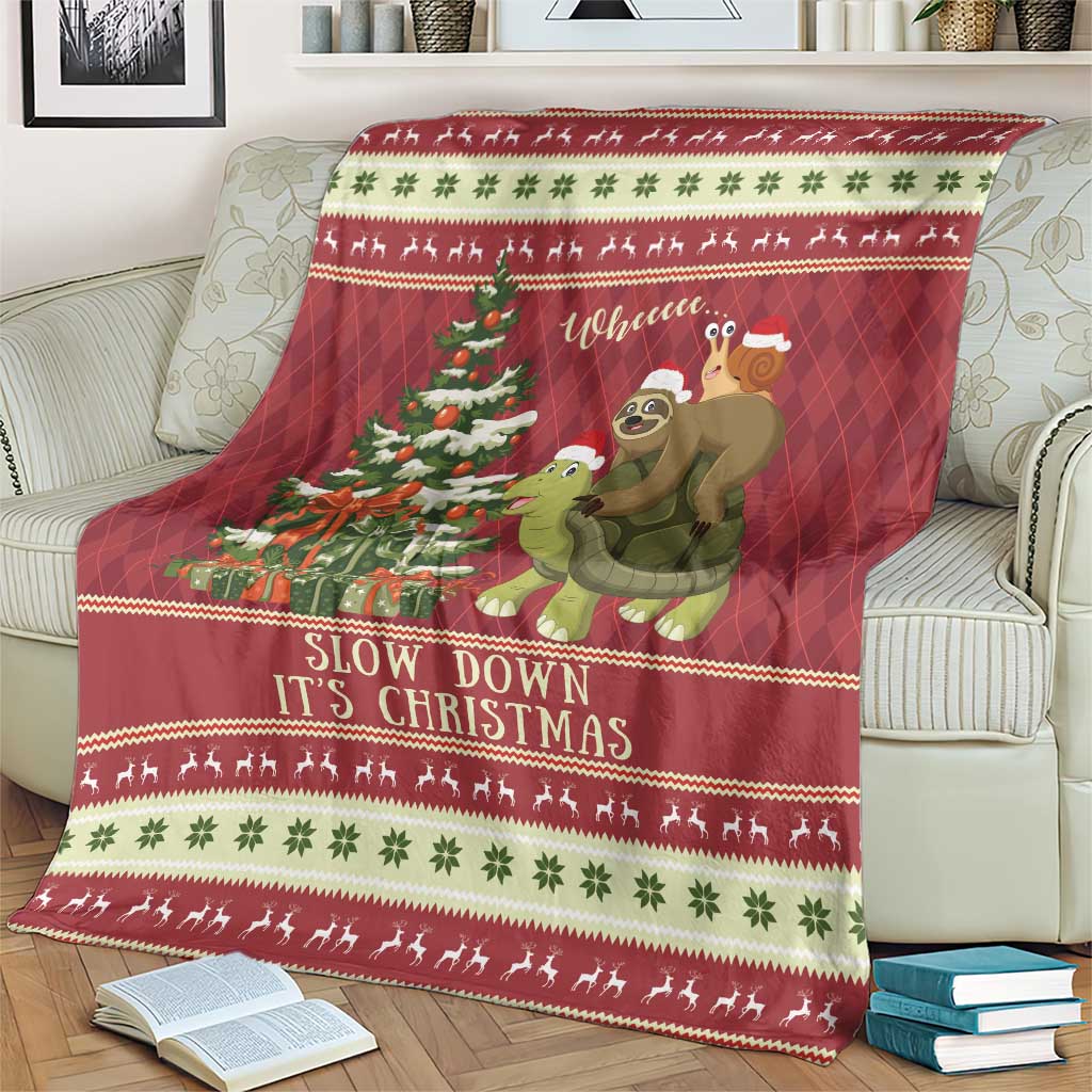 Red Christmas throw blanket on chair with sloth, turtle, trees and 'Slow Down It's Christmas'