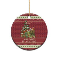 Red circular ceramic Christmas ornament with sloth and snail on turtle; gold string