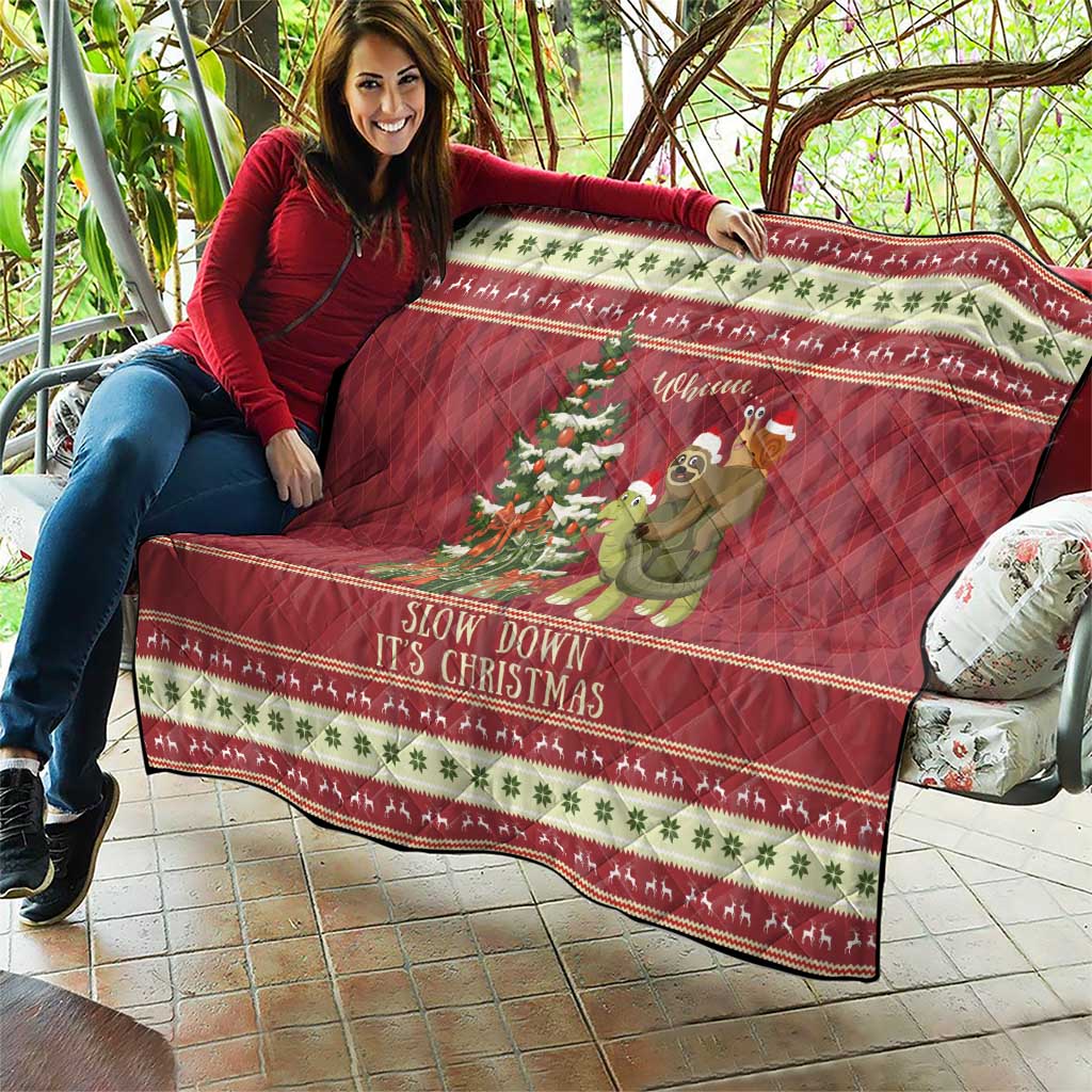 Red Christmas quilt draped for display, featuring sloth riding turtle and festive holiday border.
