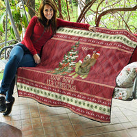 Red Christmas quilt draped for display, featuring sloth riding turtle and festive holiday border.