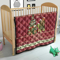 Red quilt on crib with sloth riding turtle artwork and “Slow down it’s Christmas” text.