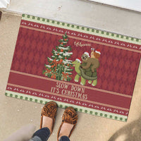 Red Christmas rubber doormat with sloth and snail riding a turtle, text 'Slow Down It's Christmas'