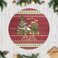 Red circular Christmas tree skirt featuring illustrated sloth and text “Slow down it’s Christmas”