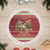 Round red Christmas tree skirt with fringe border and “Slow down, it’s Christmas” text
