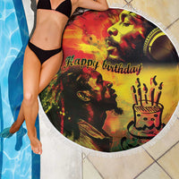 Round reggae beach blanket with fringe, 'Happy birthday' artwork, draped over poolside tiles