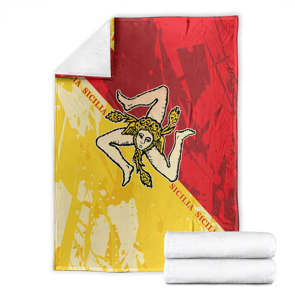 Red and yellow Sicilian flag blanket with angel emblem, folded with white towels