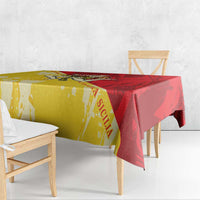 Sicily region tablecloth in gold and red, hanging over a wooden bench