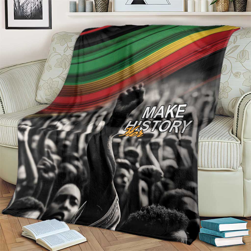 Black-and-white crowd blanket draped on a sofa with green-yellow-red stripe top