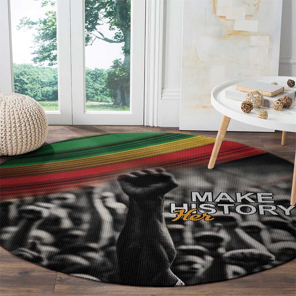 Round black carpet with Make History Her text and crowd graphic, green/red stripe band