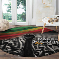Round black carpet with Make History Her text and crowd graphic, green/red stripe band