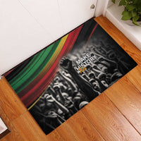Rectangular black doormat with multicolor Pan-African stripes and 'Make Her Story' logo