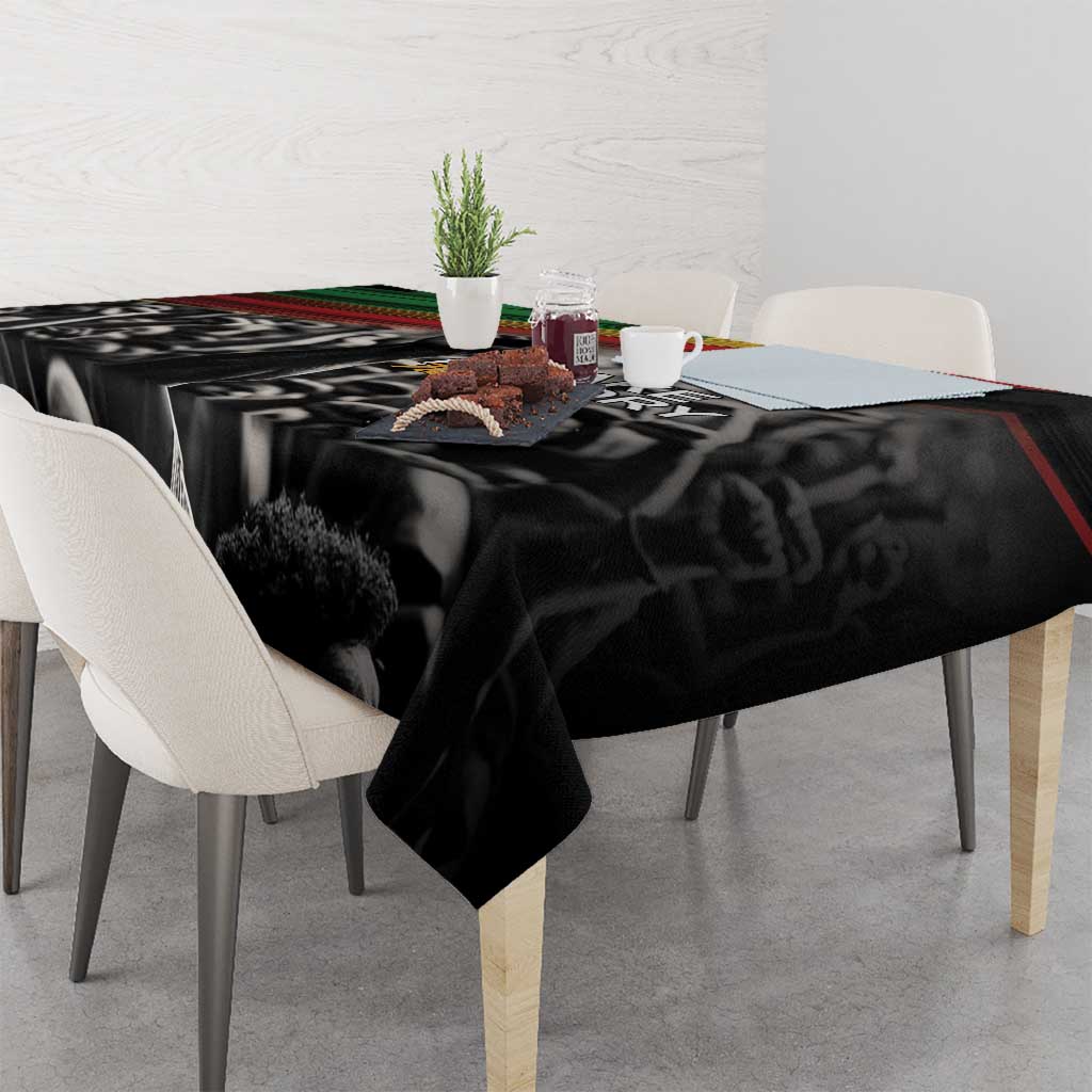 Black tablecloth with bold portrait-style figures and “Make History Her” text; multicolor stripe edge