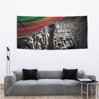 Black tapestry wall hanging with raised fist, crowd artwork, and 'Make History' wording
