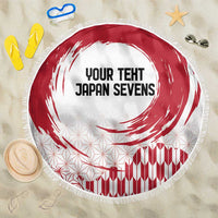Round beach blanket with red rising sun swirl, white geometric pattern, fringed edge