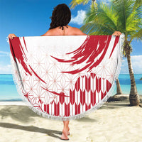 Round beach blanket with red rising sun swirl and red striped section, fringed border