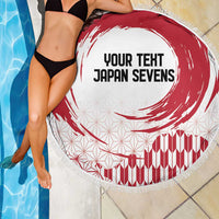 Round beach blanket with red rising sun swirl on white, fringed edge