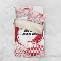 Red and white comforter and pillowcases with circle emblem, geometric pattern, and waves