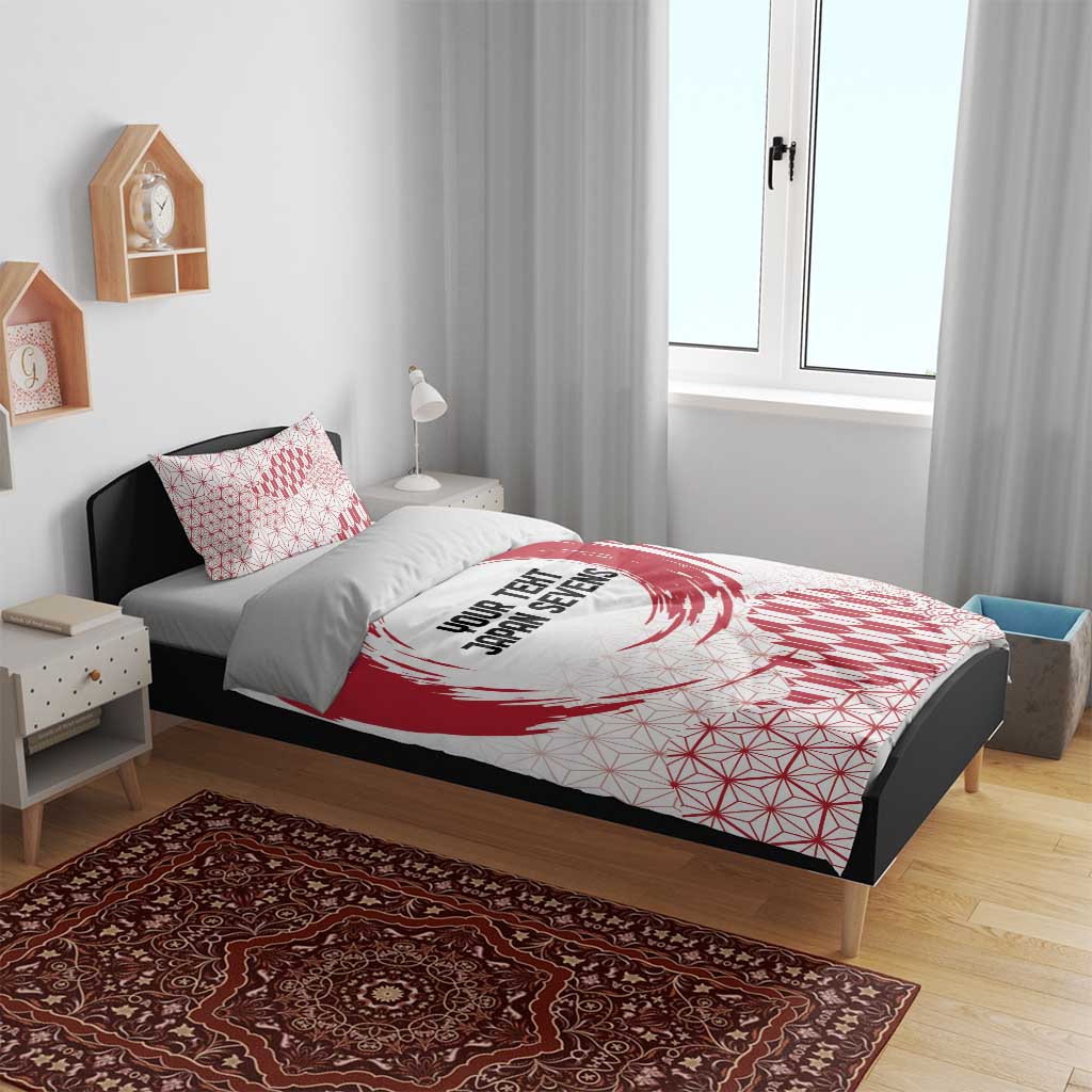 Red and white duvet on dark bed frame with matching pillowcases, emblem, and geometric pattern