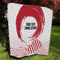 White quilt with bold red rising sun design and red wave and grid patterns along the hem.