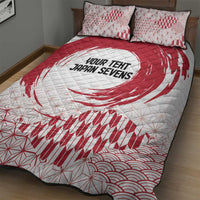 Red-and-white quilt bed set close-up: duvet with 'YOUR TENT JAPAN SEVENS' swirl, two pillows.