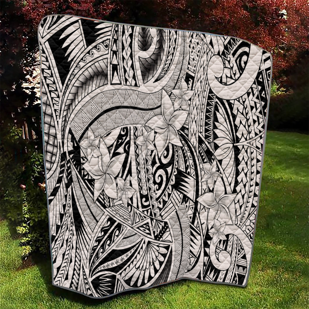 Tribal quilt blanket in black and white with swirling lines and layered floral shapes