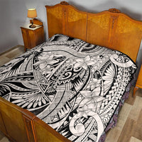 Black-and-white tribal quilt blanket with floral and geometric patterns on bed