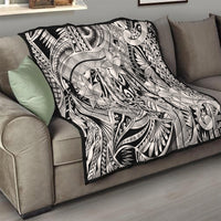 Black-and-white tribal quilt blanket draped over a sofa with ornate floral design