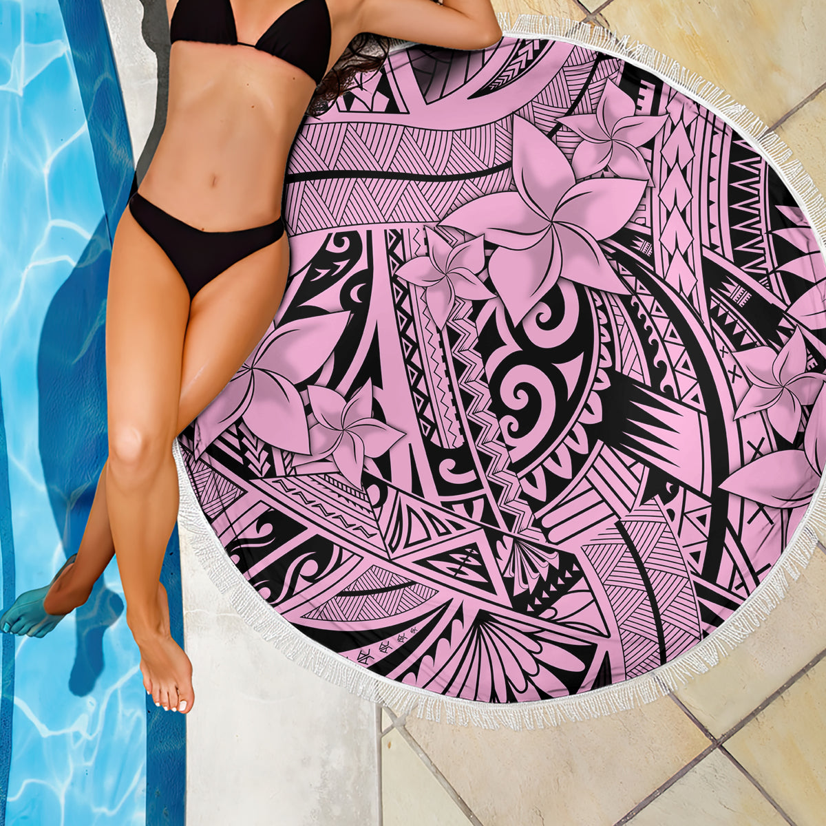Pink round beach blanket with bold black tribal swirls and flower print, fringed trim