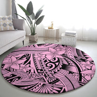 Round pink tribal rug with central swirl design and floral motifs in purple and black