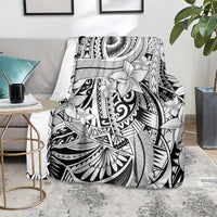 Black and white Polynesian tribal floral blanket lying on a sofa seat