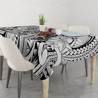 Tribal tablecloth with black-and-white floral and tiki pattern, hanging over table edge