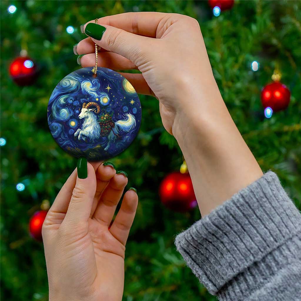Round blue ceramic goat starry night ornament being held by a hand on Christmas tree