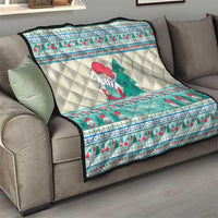 Quilted Christmas blanket draped on gray sofa with snowman and green tree in mint blue