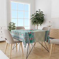 Christmas gnome tablecloth in mint blue draped on a rectangular dining table with chairs.