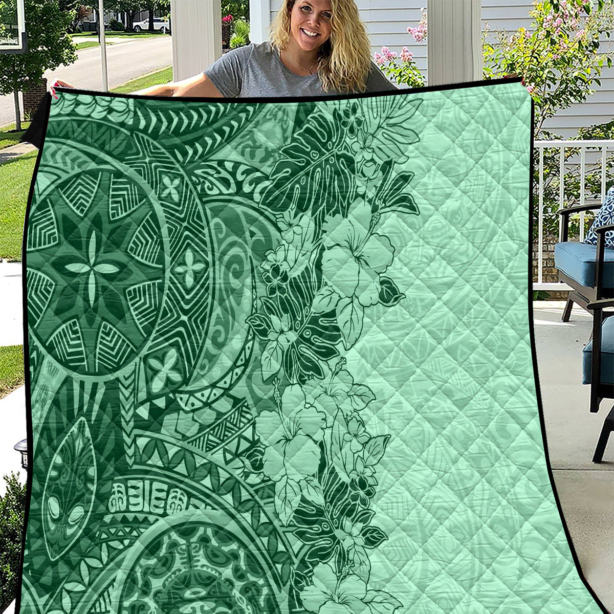 Green quilt with hibiscus and tribal tattoo print, quilted pattern, dark border trim