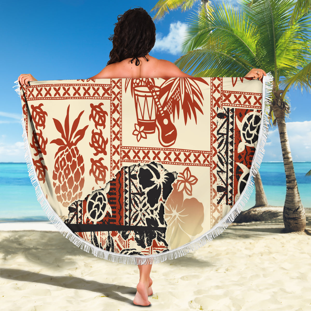 Beige round beach blanket draped with red and black tribal animal print and white fringe
