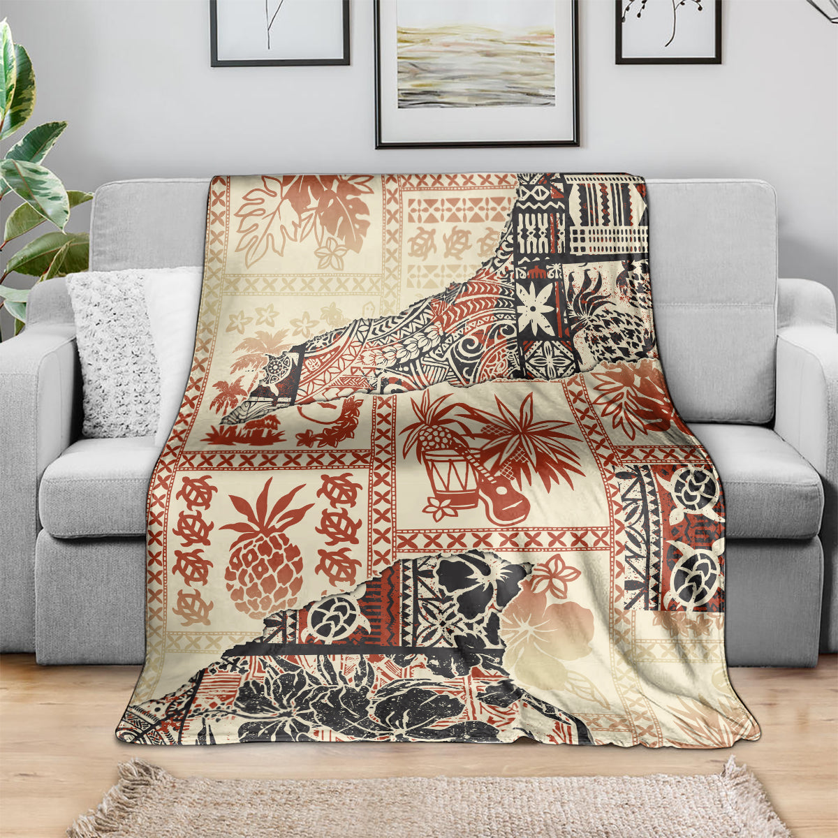 Beige throw blanket with red and black tribal motifs, spread across sofa